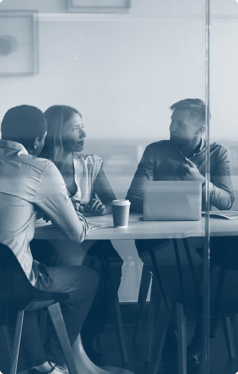 Advertising department brainstorming at modern office boardroom behind closed doors, view through the glass wall. Diverse staff led by ceo discussing new project sharing ideas thoughts and sales pitch