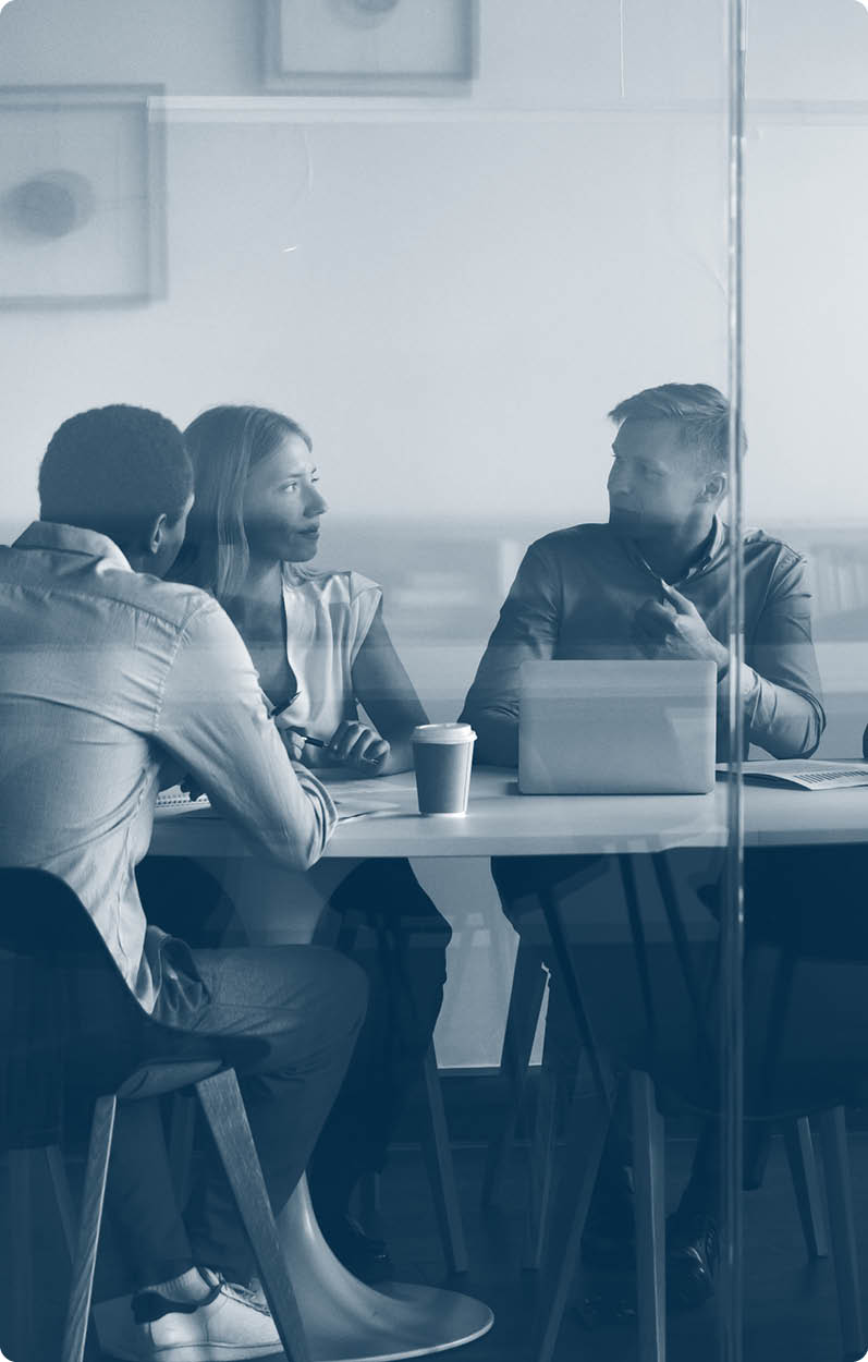 Advertising department brainstorming at modern office boardroom behind closed doors, view through the glass wall. Diverse staff led by ceo discussing new project sharing ideas thoughts and sales pitch